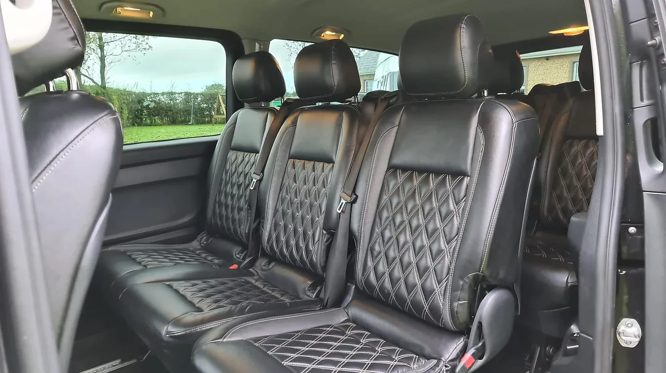Black leather diamond stitched rear seats in luxury vehicle