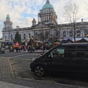 Chauffeur van parked outside Belfast City Hall during a busy market day